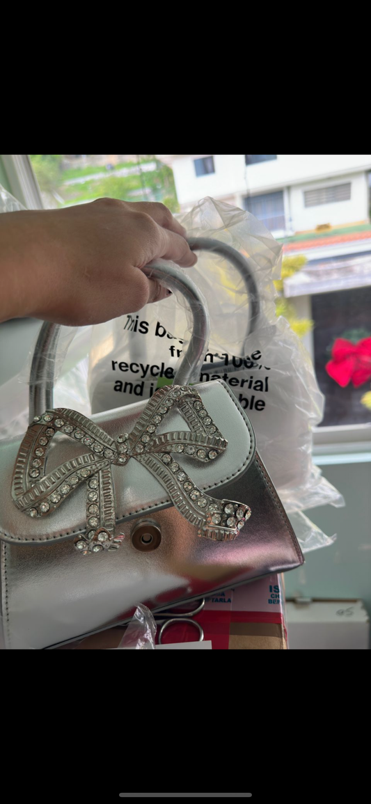 Cartera plateada lazo brilante